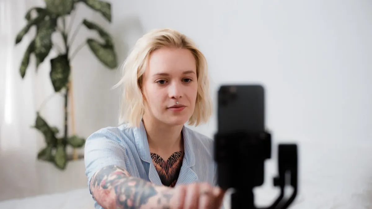 Criadora de conteúdo ajustando smartphone em tripé para gravar vídeo