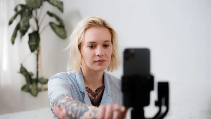 Criadora de conteúdo ajustando smartphone em tripé para gravar vídeo